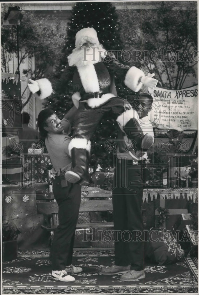 1988 Press Photo Santa Claus lifted by Northwestern Mutual employees, Milwaukee - Historic Images