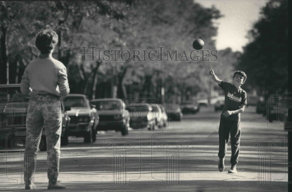 1987 Steve St. John throws football to sister, Sharon, Milwaukee-Historic Images