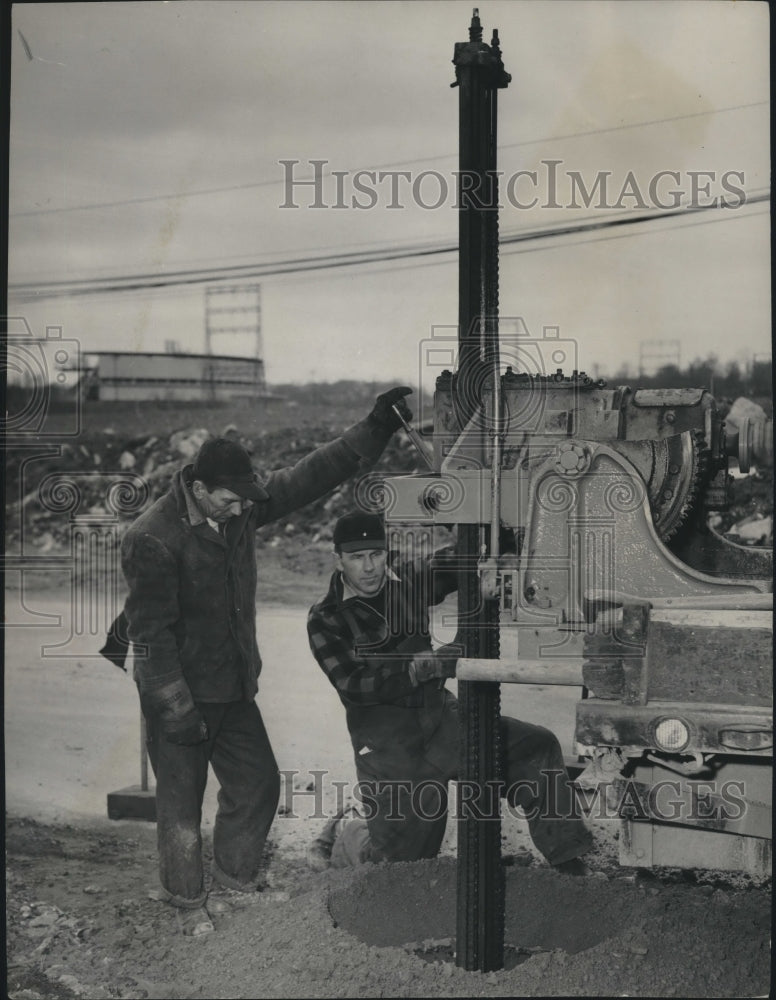 1953 Press Photo Milwaukee Stadium drilling holes to stake net behind home plate - Historic Images