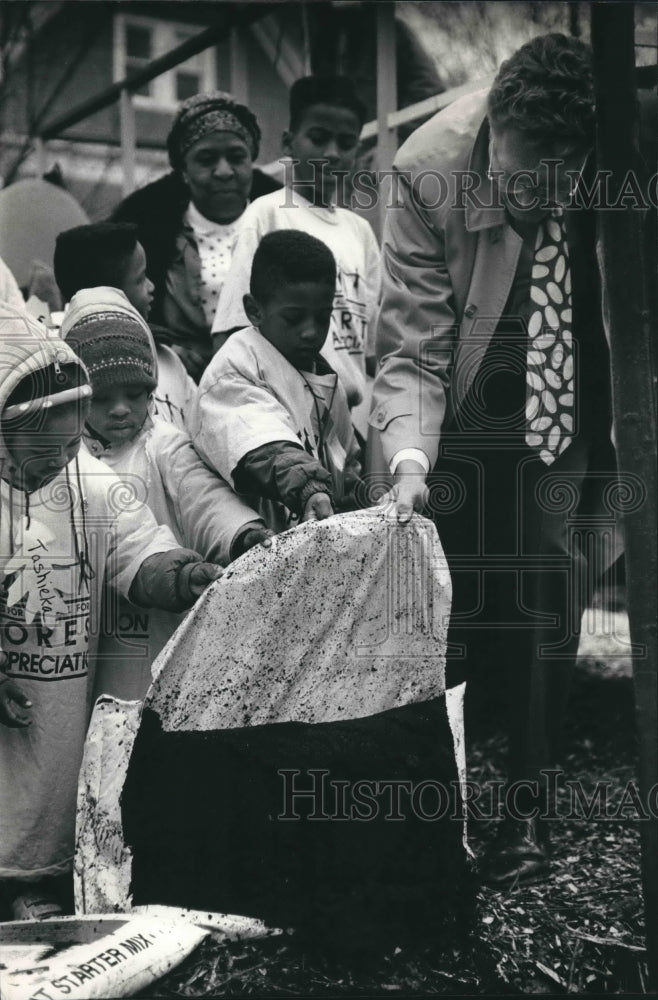 1992 Press Photo Mayor John Norquist, kids pouring soil around tree, Arbor Day. - Historic Images