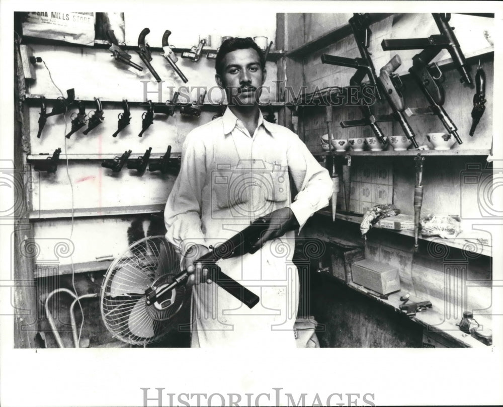 1978 Shopkeeper displaying a gun at Bara Market, a Pakistan Industry-Historic Images