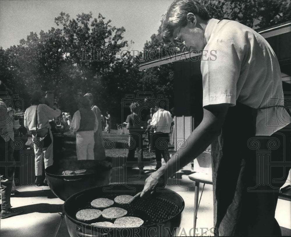 1986 Mark Nowakowski grilling hamburgers for school picnic, Hartland - Historic Images
