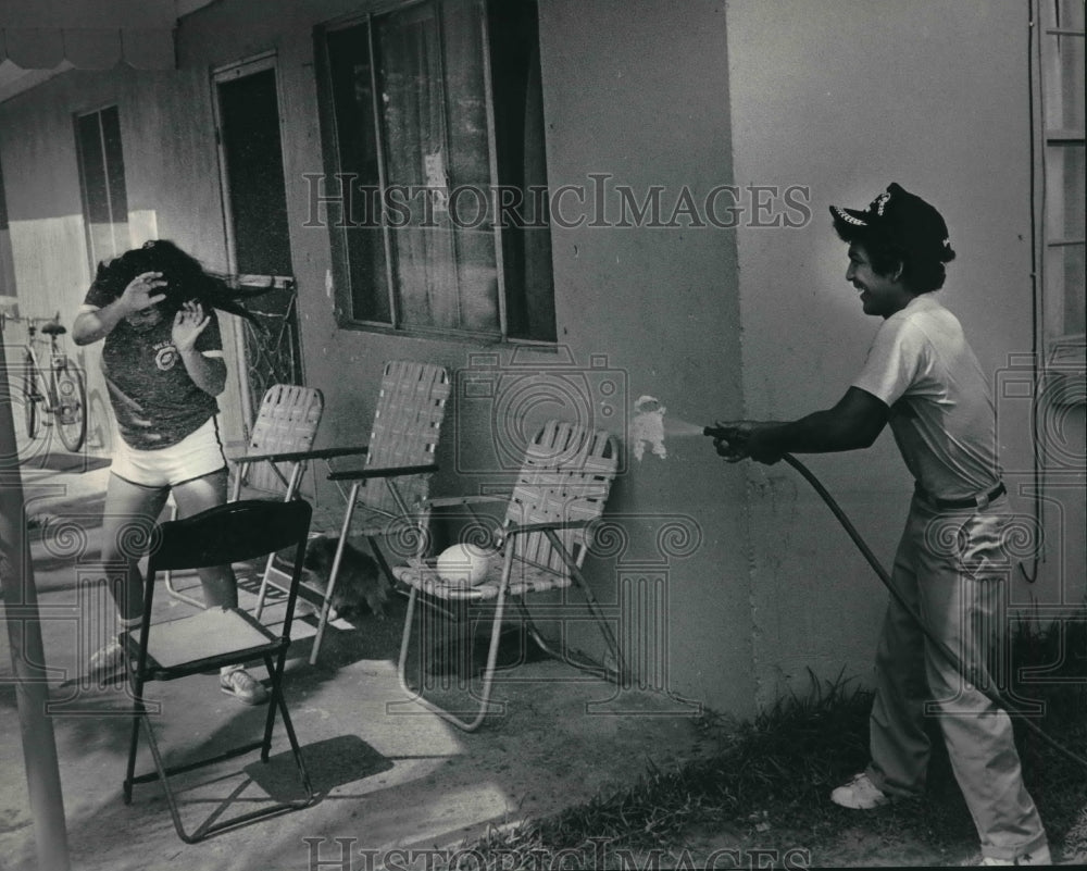 1983 Press Photo David Garces turns hose on sister in Weslaco, Texas - mjb63923 - Historic Images