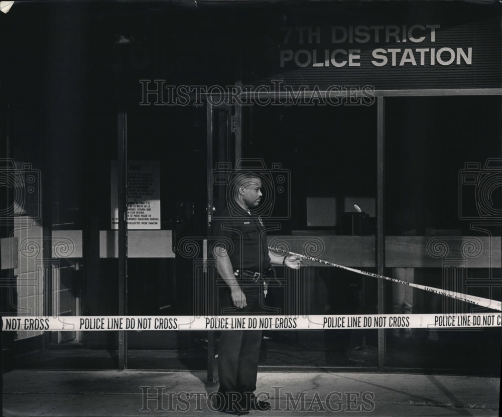 1992 Milwaukee Police Officer stands at crime scene tape - Historic Images