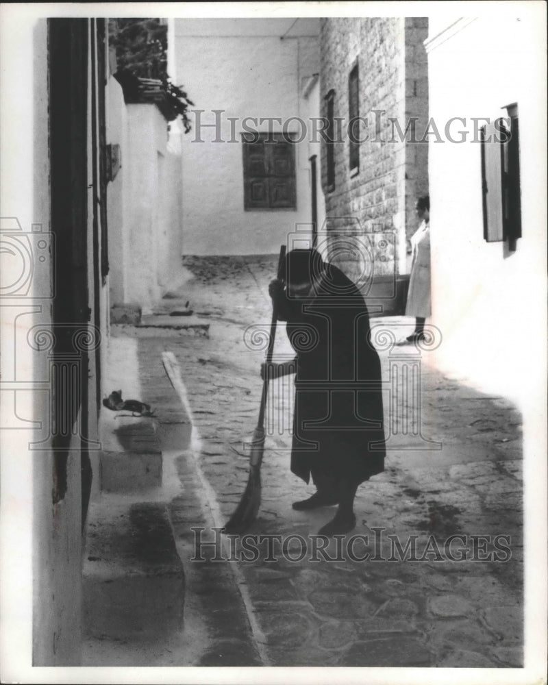 1970 Press Photo Elderly resident of an island in Greece sweeps stone streets-Historic Images