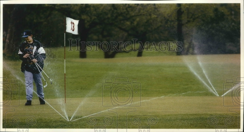 1993 Chris Leopold, Lake Park Golf Course, sprinklers came on - Historic Images