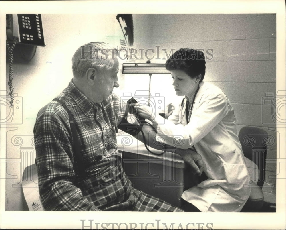 1987 Press Photo Milwaukee Nurse Katie Feldman checks patients blood pressure - Historic Images