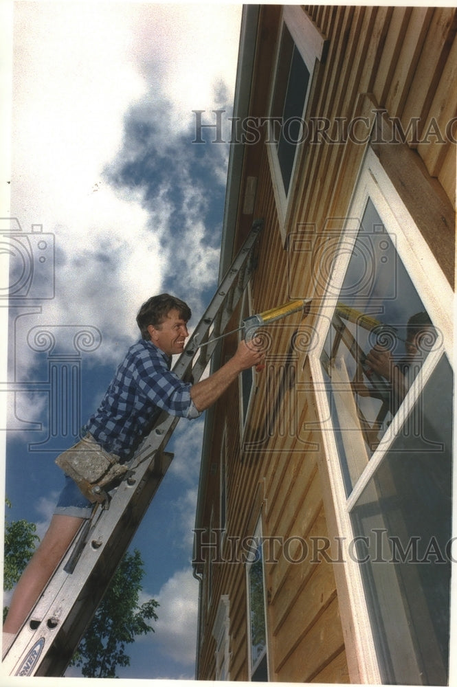 1994 Steve Frisch, Frisch Weatherstrip caulks house, Menomonee Falls - Historic Images