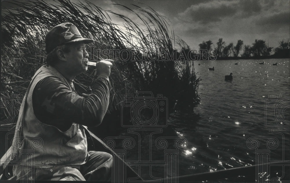 1990 Ed Chin calls ducks over decoys on Sinissippi Lake - Historic Images