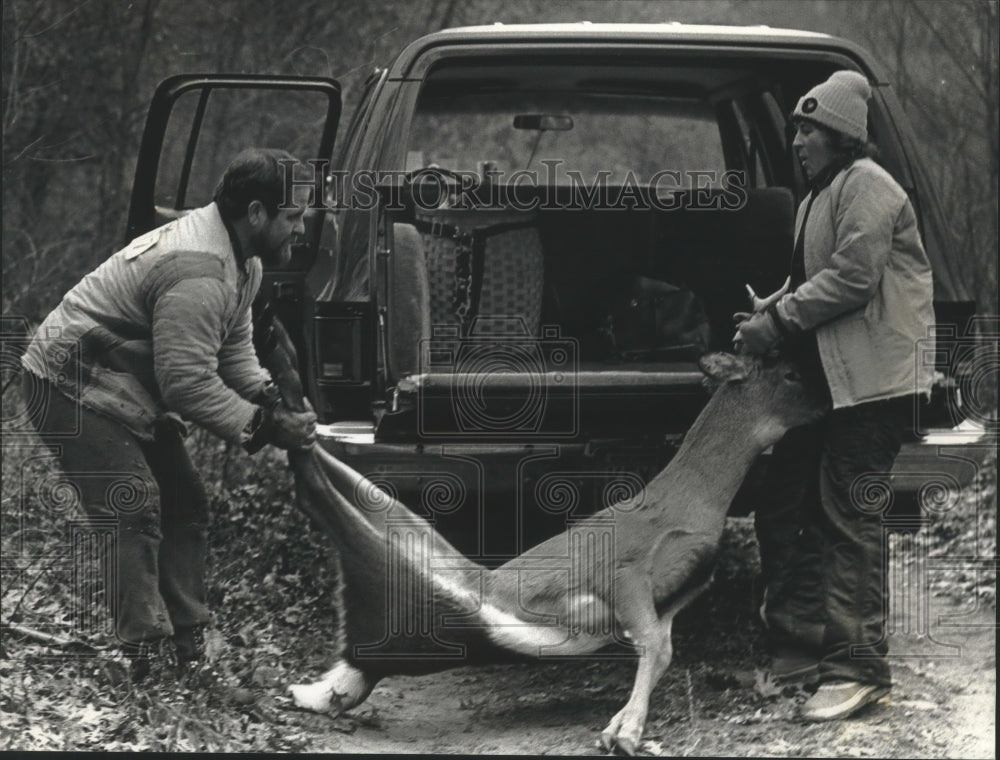 1992 Bob and Bonnie Davis load buck into truck - Historic Images