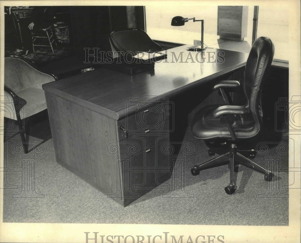 1986 A cherry desk with brass trim and soft chair, Milwaukee. - Historic Images