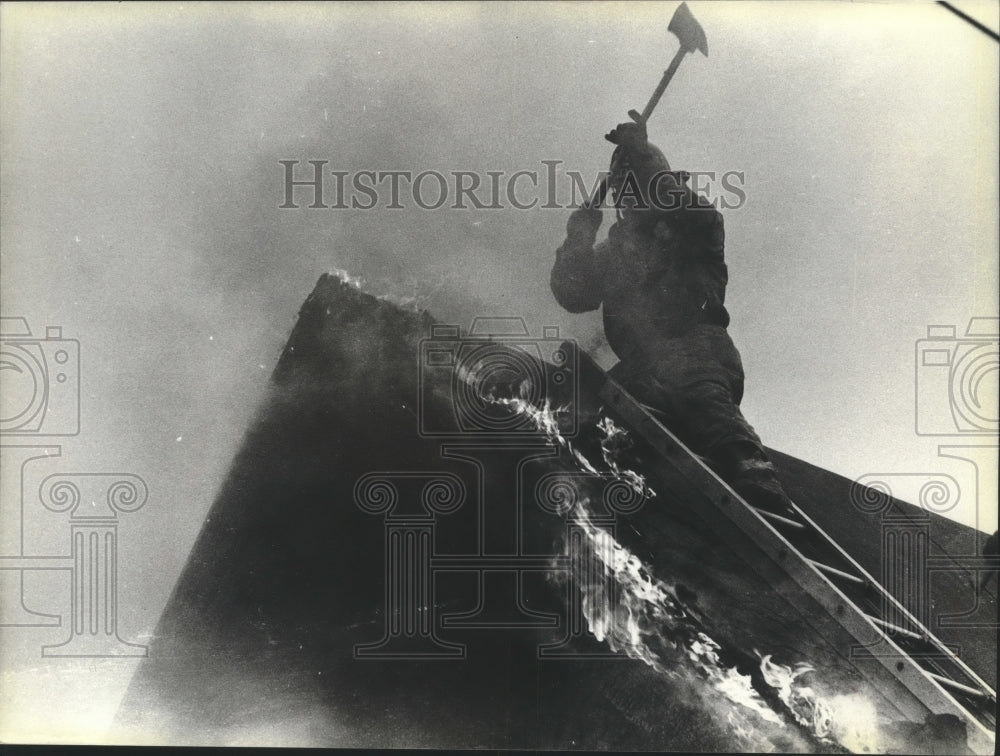 1979 Milwaukee firefighter cuts hole in roof to battle house fire.-Historic Images