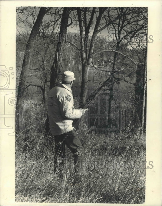 1986 Deer hunter watching a wooded draw in Wisconsin - Historic Images
