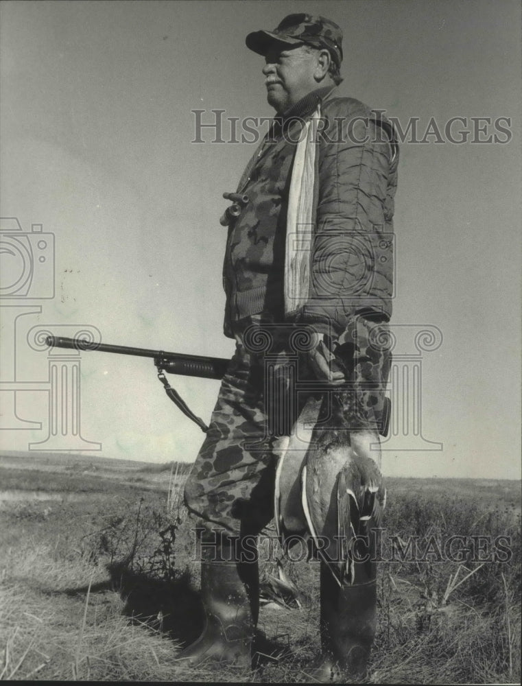 1985 Bill Peterburs carries ducks from hunting trip in North Dakota - Historic Images