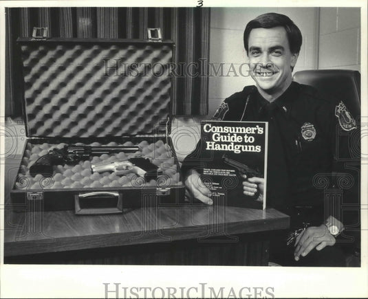 1986 Press Photo New Berlin Lt. Michael Neuens holds a guide to handguns - Historic Images