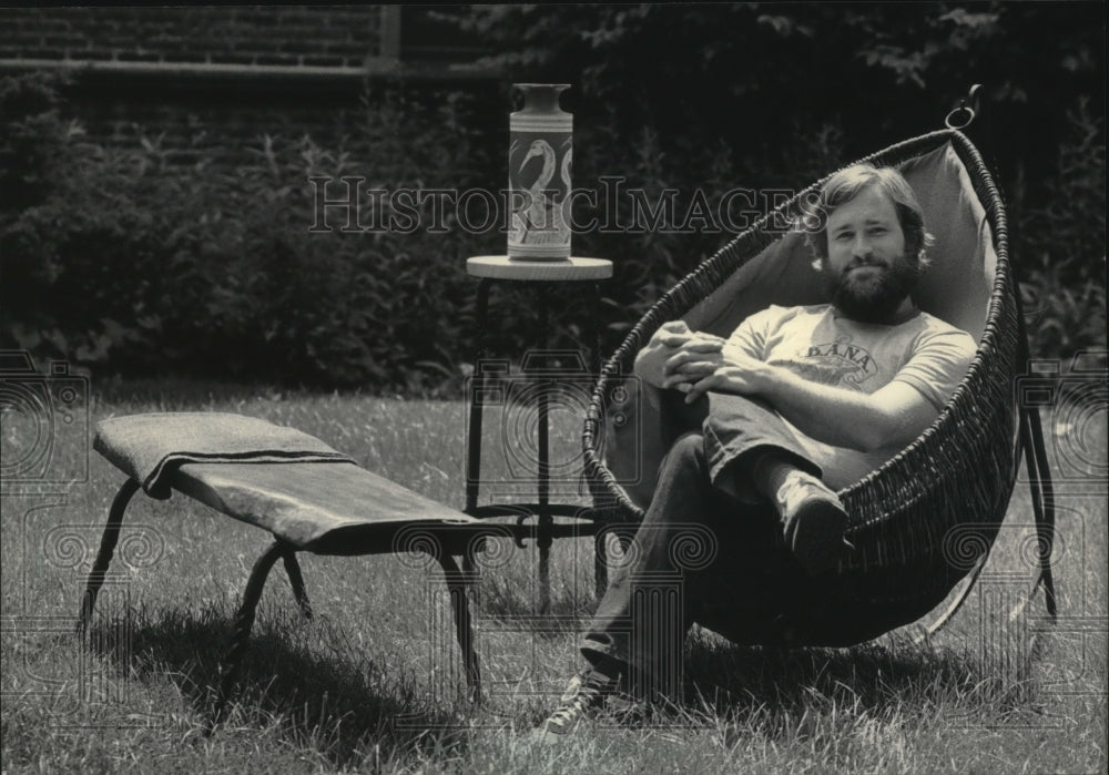 1984 Robert Myran, relaxing in woven chair, Milwaukee - Historic Images