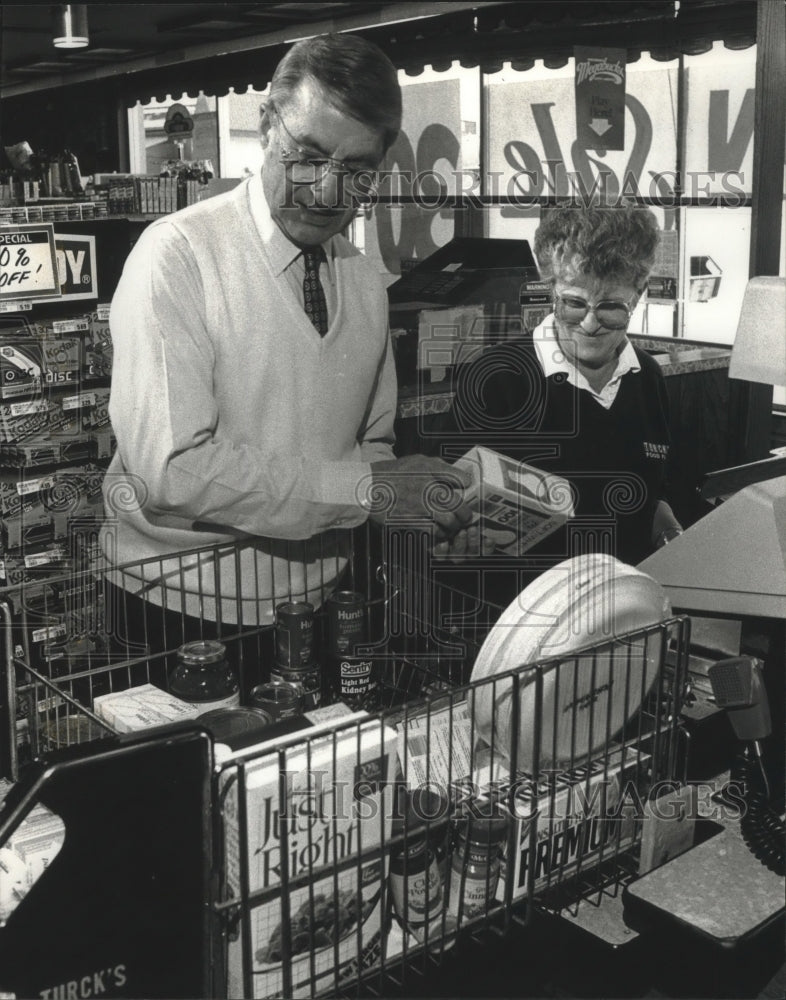 1990 Oner helped employee ring up groceries at Turck&#39;s Food Fare - Historic Images