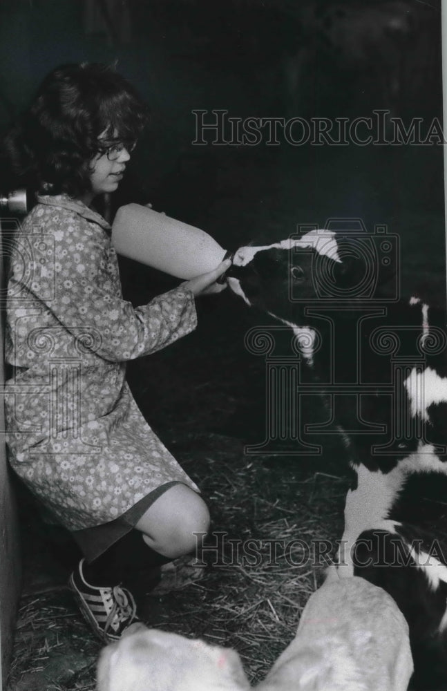 1978 Janine Arnold feeds calf on family farm - Historic Images