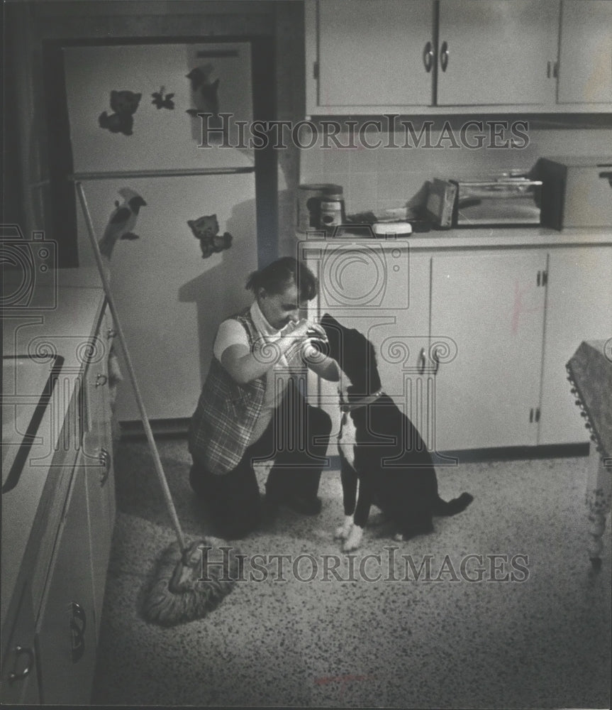 1976 Unidentified lady feeds dog at the Hales Corners Center-Historic Images