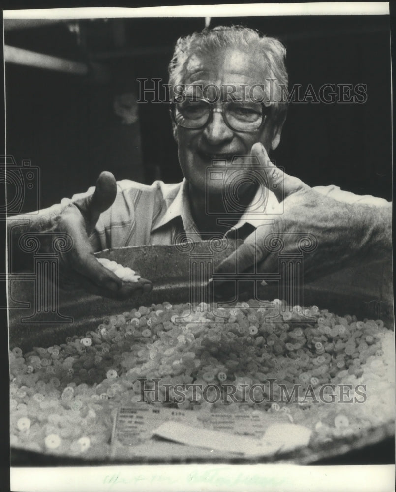 1983 Press Photo J &amp; K President H. Bernard Hahn sifted through plastic buttons - Historic Images