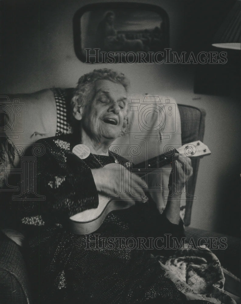 1989 Press Photo Marcella Munson playing a ukulele in her Milwaukee home - Historic Images