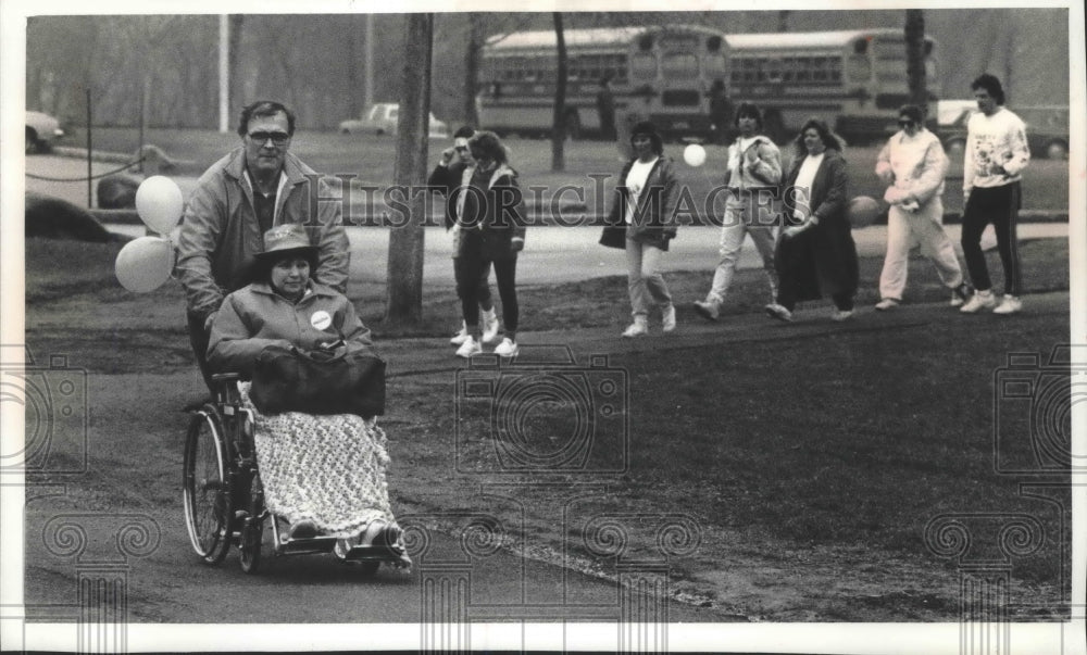 1990 Press Photo Bill Lundh pushes his friend Carol Miller through Lake Park - Historic Images