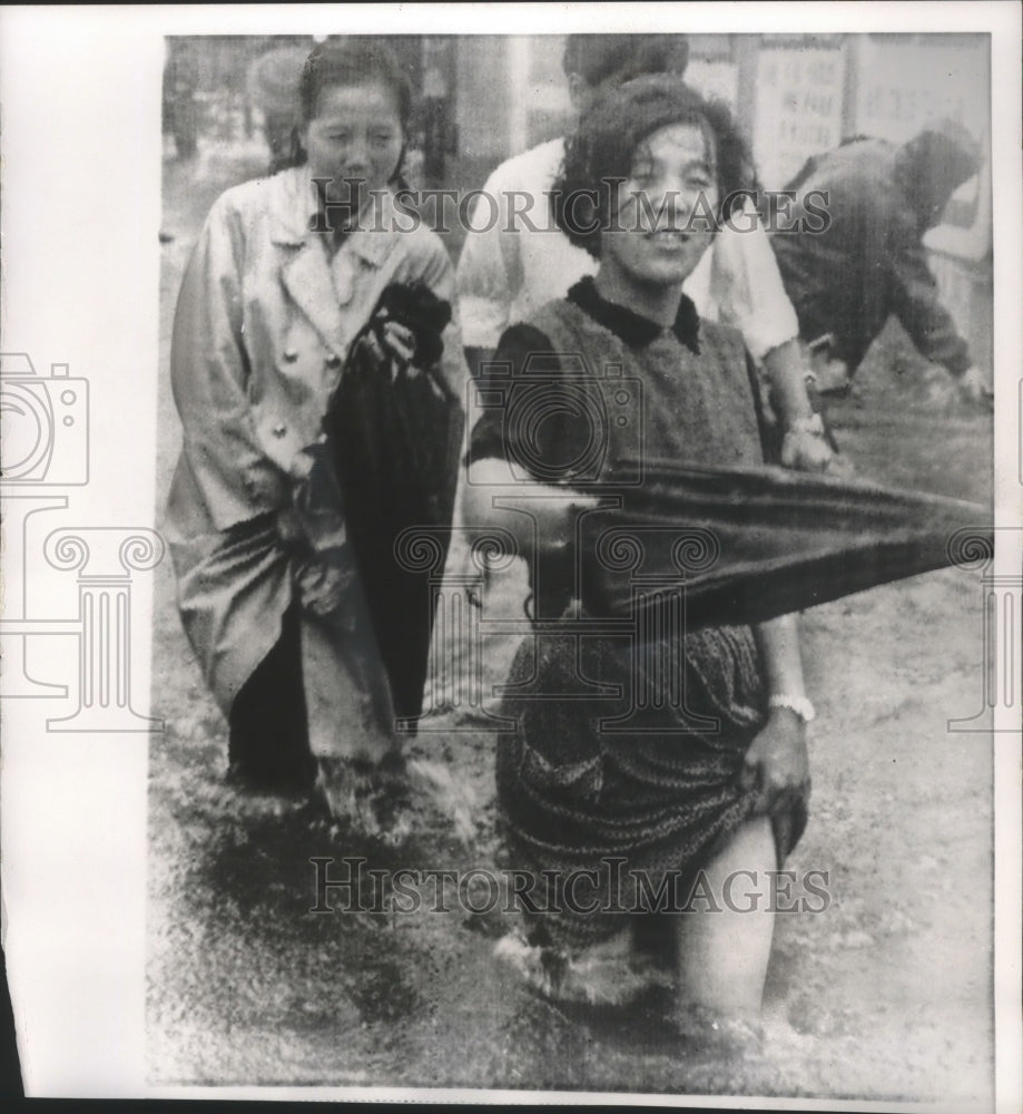 1966 Japan, commuters in Tokyo&#39;s Nakano district after typhoon Kit-Historic Images