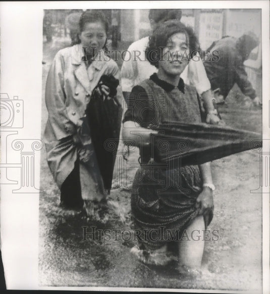 1966 Japan, commuters in Tokyo's Nakano district after typhoon Kit-Historic Images