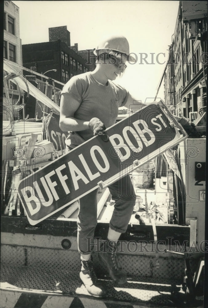 1987 Press Photo City employee Chris Brotz puts up sign for Milwaukee parade - Historic Images