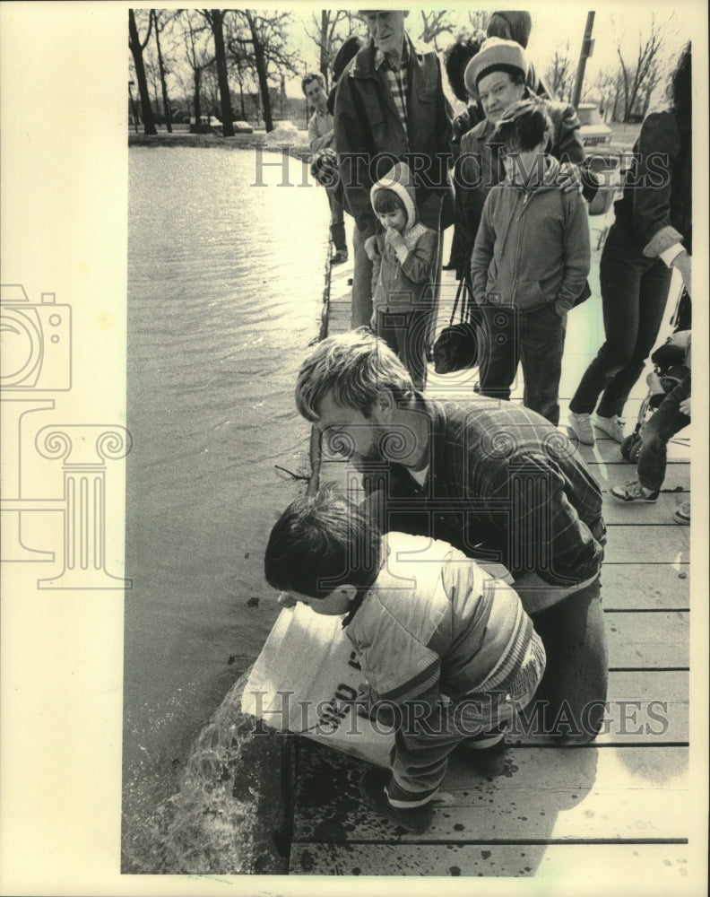 1986 Press Photo Jacob Mai, 4, helped Roger Kunz plant trout at Humboldt Park - Historic Images