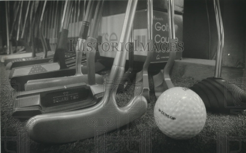 1993 Golf ball and putters of different size, shapes and materials - Historic Images