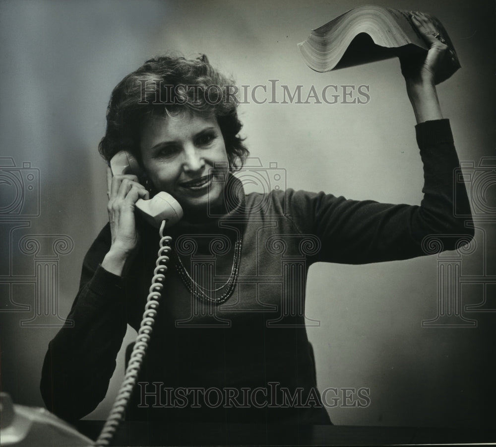 1983 Author Eleanor Rowe exercises with phone book while on phone - Historic Images