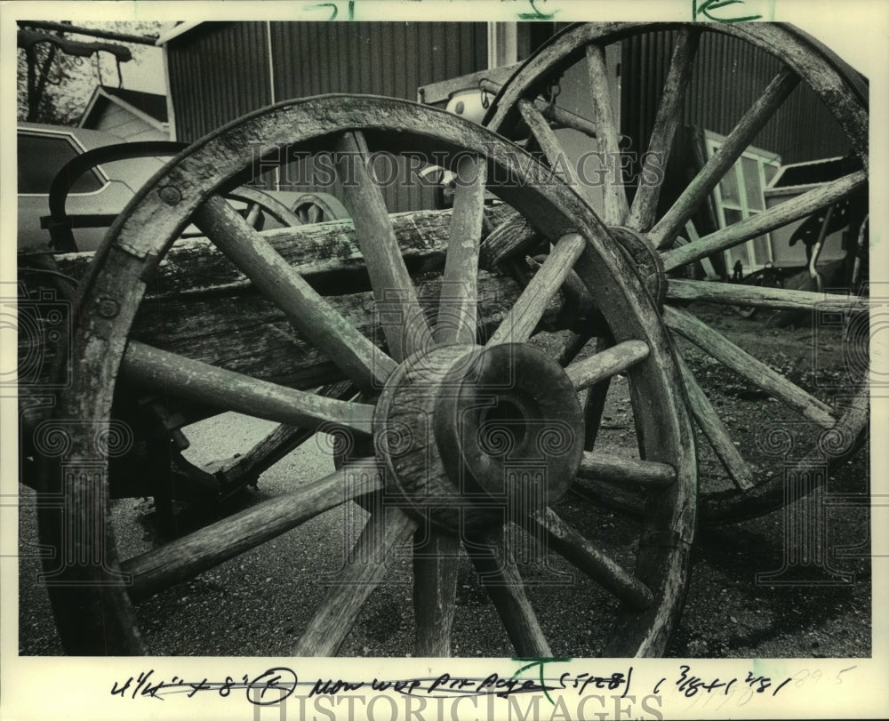 1984 Weathered and worn wagon wheels at store - Historic Images