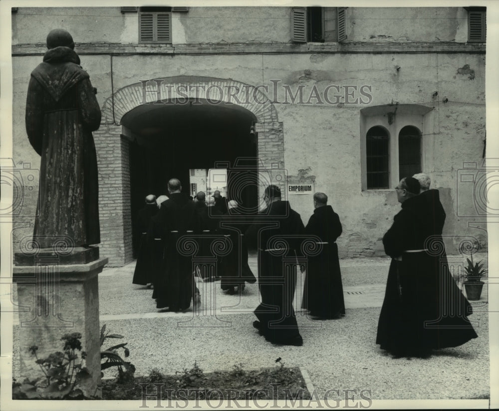 1957 Friars walk into Monastery past a statue of St. Francis - Historic Images