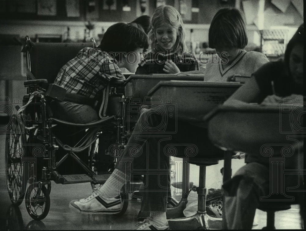 1979 From her wheelchair, Michelle Kearney shared desk & assignment - Historic Images