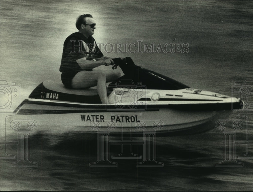 1991 South Milwaukee policeman Mick Olson patrols lake on a jet boat - Historic Images