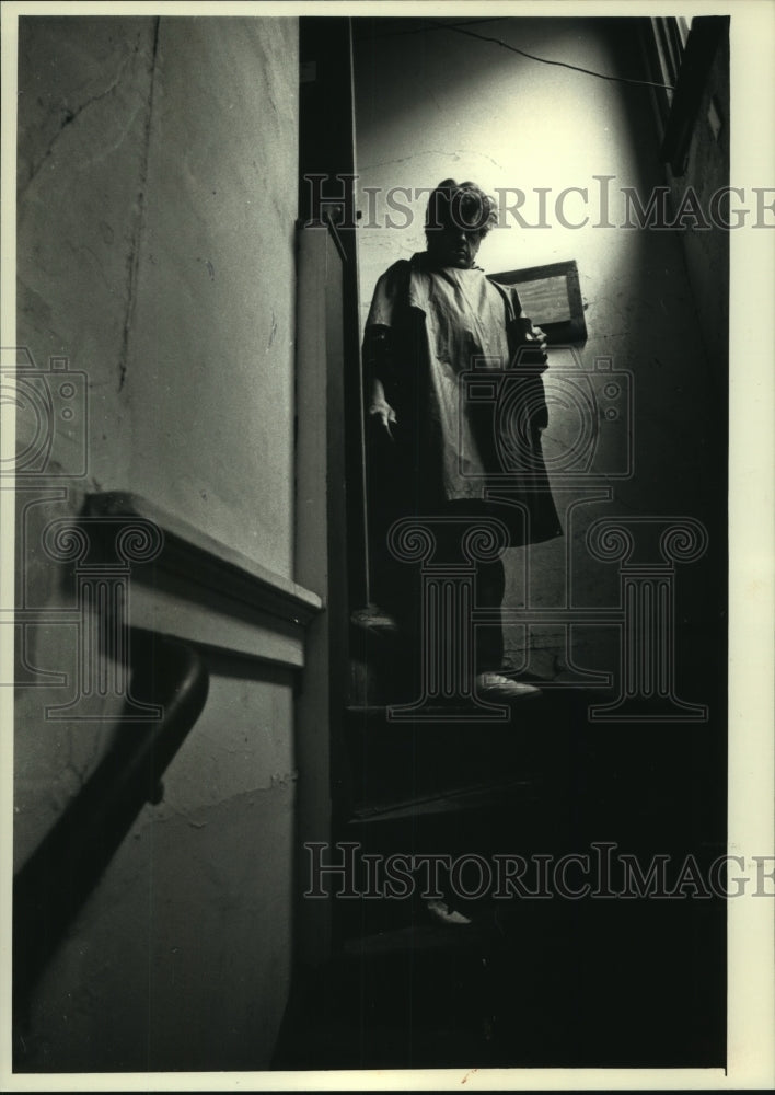 1991 John walking down stairs from room in Waukesha Hotel. - Historic Images