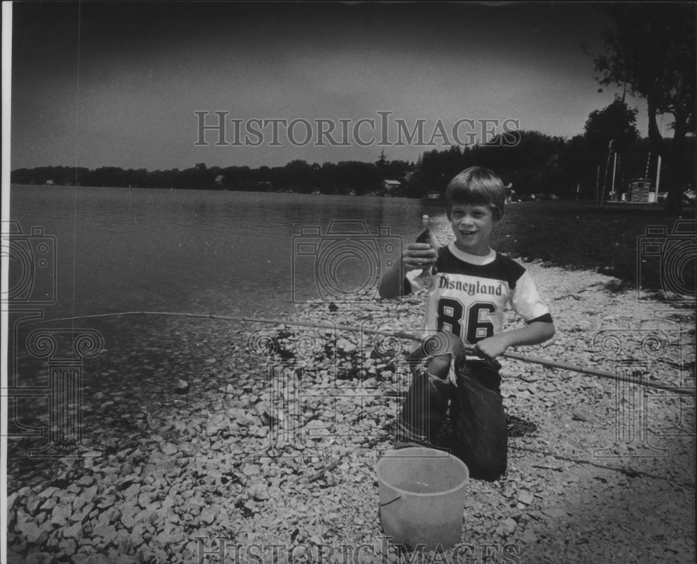 1986 Press Photo Peter Conrad, Onalaska catches fish in Pewaukee Lake, Wisconsin - Historic Images