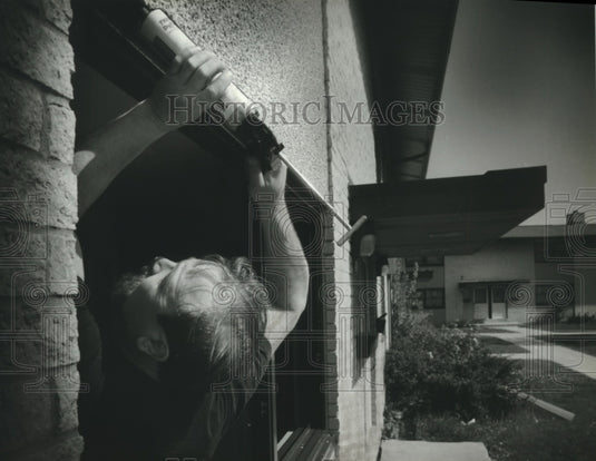 1993 Worker caulks windows, Milwaukee Housing project-Historic Images