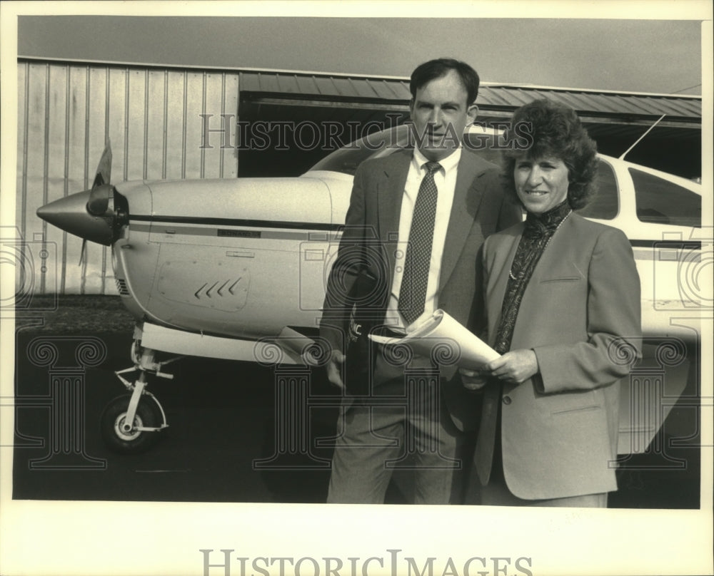 1987 Owners Julie and Jim Peck front of airplane, Management Search-Historic Images