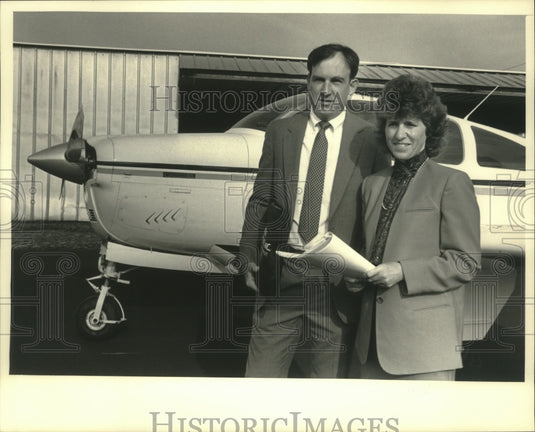 1987 Owners Julie and Jim Peck front of airplane, Management Search-Historic Images