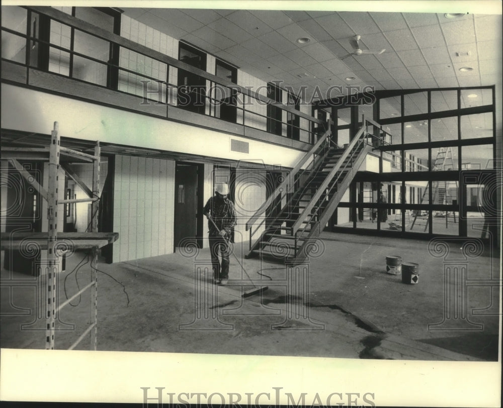 1986 Press Photo Worker sweeps prison area at Oshkosh Correctional Institution - Historic Images