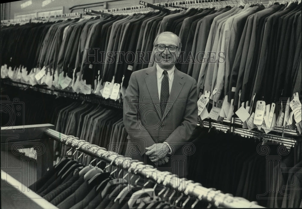 1985 Albion Kahn standing amid suits, Kahn Clothing, Milwaukee-Historic Images