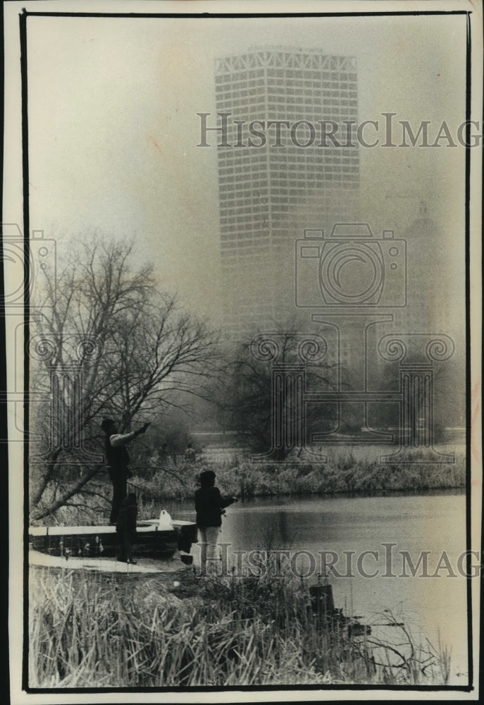 1989 Press Photo A family fishes the fog-shrouded Juneau Park Lagoon, Milwaukee - Historic Images