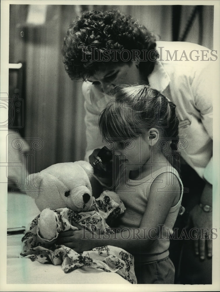 1988 A nurse at St. Francis Hospital shows Brandy Williams her work.-Historic Images