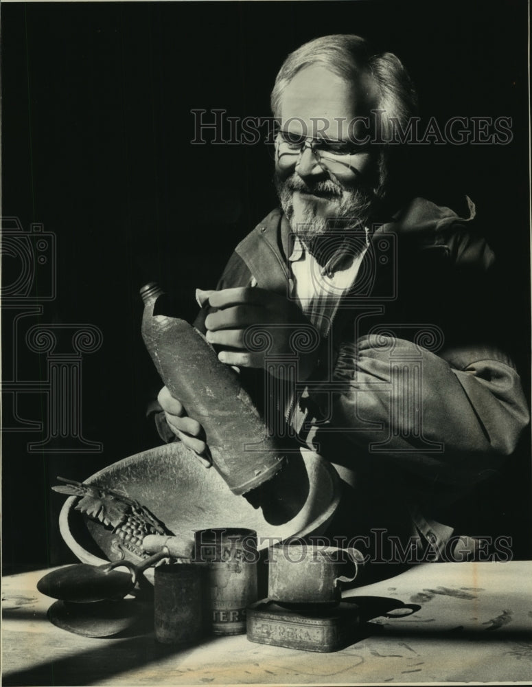 1988 Press Photo Milwaukee Archdiocese Archivist, Father Falt examines bottle - Historic Images