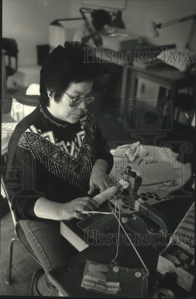 1991 Press Photo Carol Tucker using press to cut wafers from a sheet, Milwaukee. - Historic Images