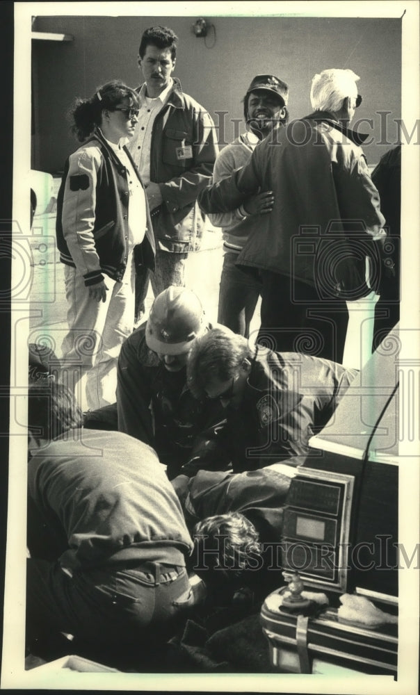1988 Emergency workers restrain a friend of victim Anthony Sample - Historic Images