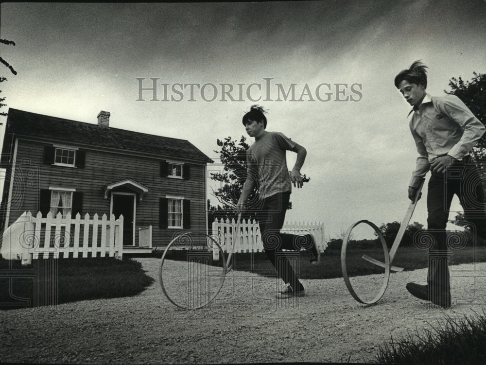 1972 Press Photo Two boys roll barrel hoops along the road Cedarburg - mjb89416 - Historic Images