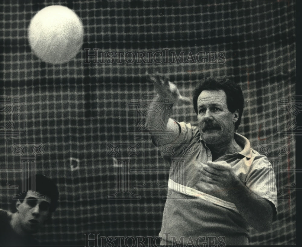 1991 VWM coach Tom Pleyte serves a volleyball - Historic Images